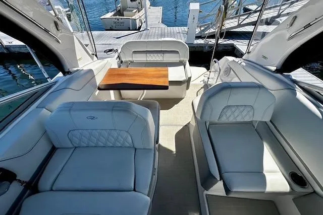 Slide: The Image of Luxurious 2022 Regal 26 XO boat interior with plush seating and wooden table at dock. - 3