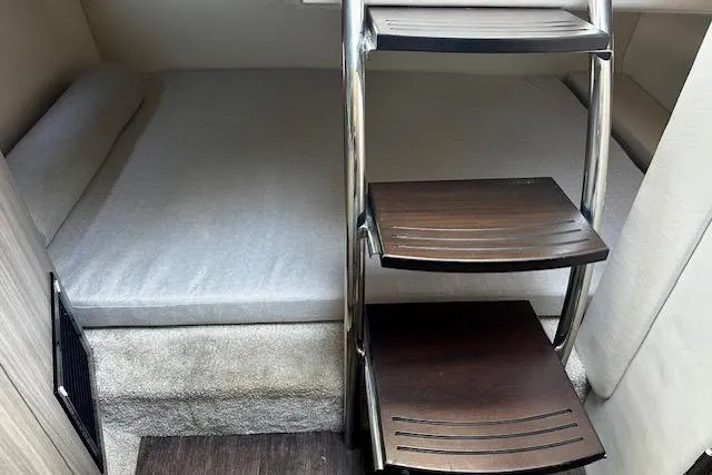 Slide: The Image of 2022 Regal 26 XO cabin interior with bed and wooden steps. - 8