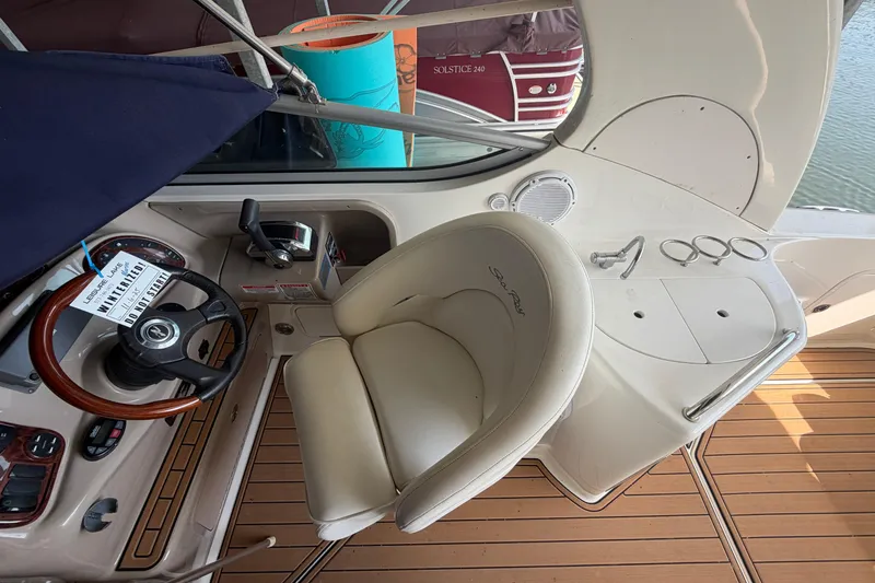 Slide: The Image of 2005 Sea Ray Sundancer 280 helm with steering wheel and control panel, featuring teak flooring. - 12