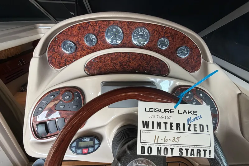 Slide: The Image of 2005 Sea Ray Sundancer 280 dashboard with winterization notice, wood accents, and gauges. - 15