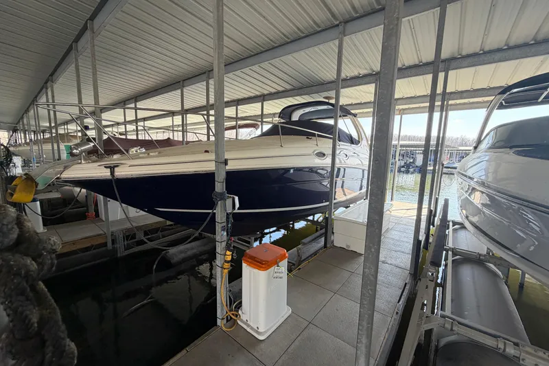 The Image of 2005 Sea Ray Sundancer 280 docked in a covered marina slip. - 2