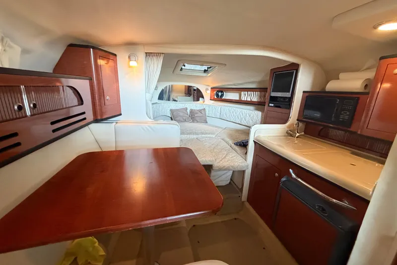 Slide: The Image of Interior of 2005 Sea Ray Sundancer 280, featuring cozy cabin with dining area and kitchenette. - 26