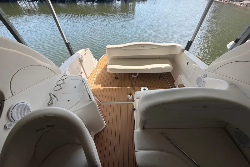 Slide: The Image of 2005 Sea Ray Sundancer 280 boat interior with seating and wood deck, docked by water. - 6