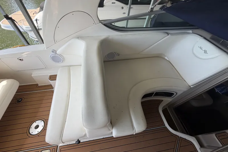Slide: The Image of 2005 Sea Ray Sundancer 280 boat interior with white seating and teak flooring. - 9