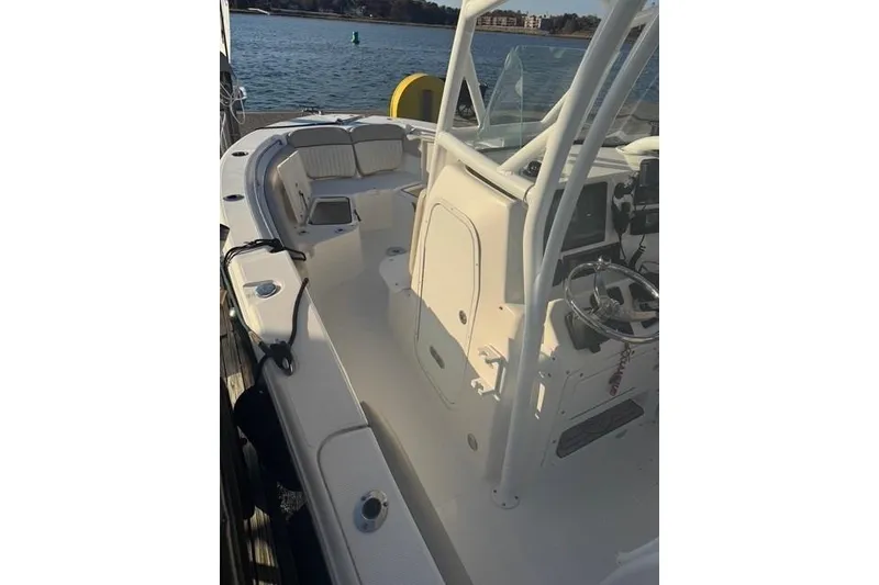 Slide: The Image of 2015 Sea Fox 249 Avenger boat interior with steering console, docked by the water. - 6