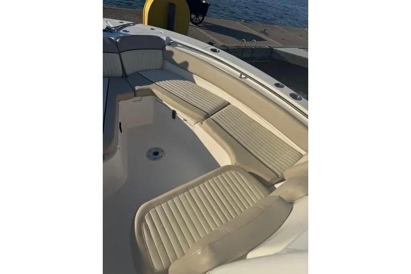 Slide: The Image of 2015 Sea Fox 249 Avenger boat interior with beige cushioned seating by the water. - 7