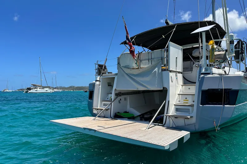 Slide: The Image of 2019 Beneteau Oceanis Yacht 62 anchored in clear blue waters. - 10
