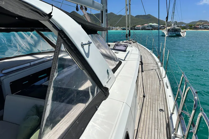 Slide: The Image of 2019 Beneteau Oceanis Yacht 62 sailing in turquoise waters near scenic coastline. - 13