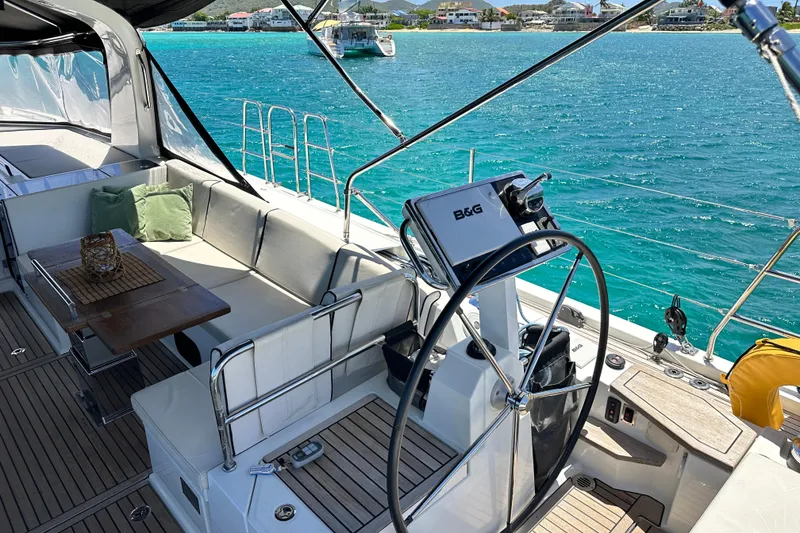 Slide: The Image of Luxurious 2019 Beneteau Oceanis Yacht 62 cockpit with elegant seating and stunning ocean view. - 19