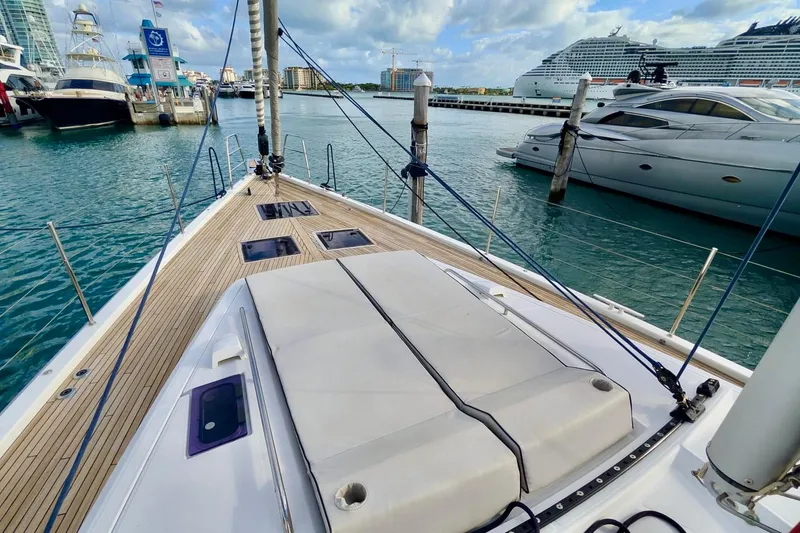Slide: The Image of 2019 Beneteau Oceanis Yacht 62 docked in a marina, showcasing sleek deck design. - 21