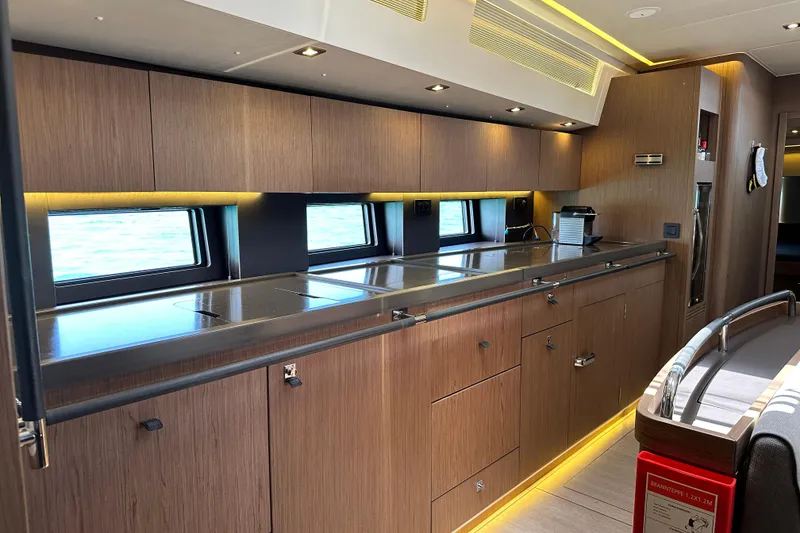 Slide: The Image of Luxurious kitchen interior of 2019 Beneteau Oceanis Yacht 62 with sleek wood cabinetry. - 24