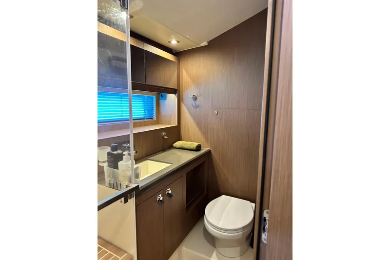 Slide: The Image of Luxurious bathroom in 2019 Beneteau Oceanis Yacht 62 with modern fixtures and wood accents. - 29