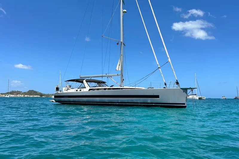 Slide: The Image of 2019 Beneteau Oceanis Yacht 62 sailing on clear blue waters under a sunny sky. - 6