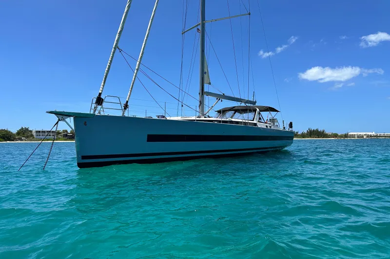 Slide: The Image of 2019 Beneteau Oceanis Yacht 62 sailing on clear turquoise waters under a blue sky. - 8
