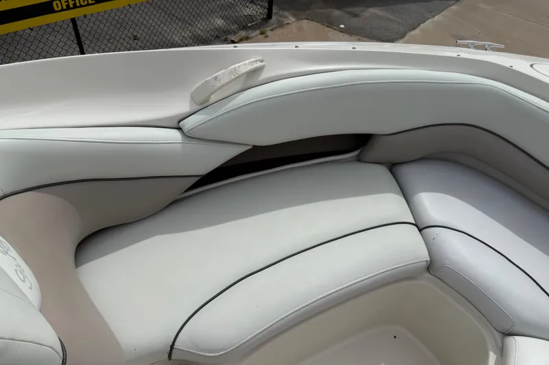Slide: The Image of 2003 Sea Ray 240 Bow Rider interior seating with white upholstery. - 17
