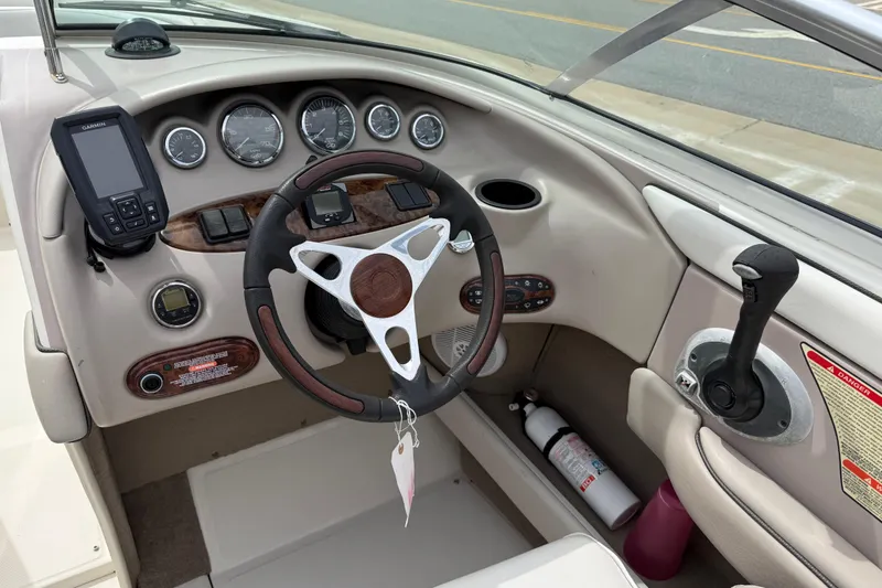 Slide: The Image of 2003 Sea Ray 240 Bow Rider dashboard with steering wheel, gauges, and controls. - 26