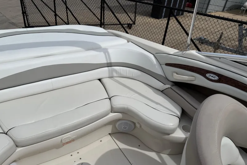 Slide: The Image of 2003 Sea Ray 240 Bow Rider interior with white leather seating and wood accents. - 29