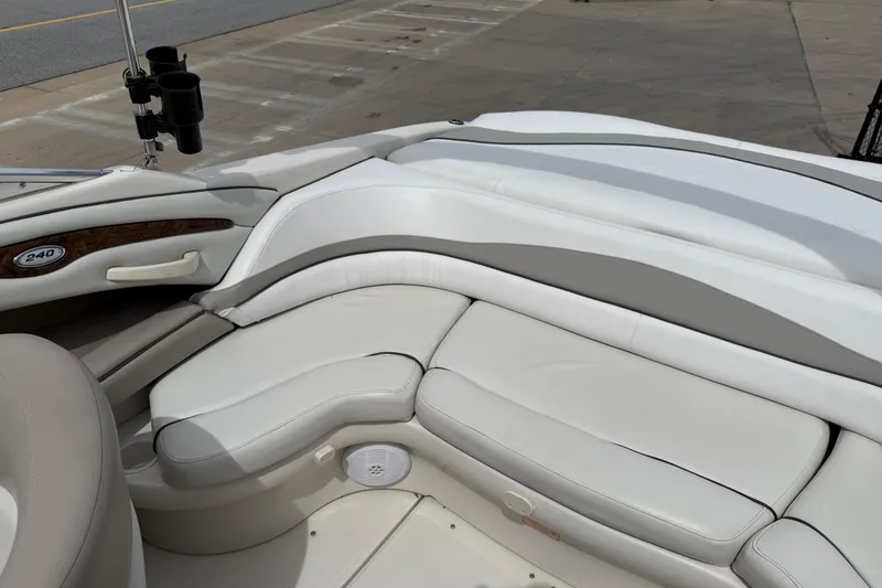 Slide: The Image of 2003 Sea Ray 240 Bow Rider interior with white leather seating and cup holders. - 30