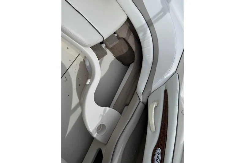 Slide: The Image of Interior view of a 2003 Sea Ray 240 Bow Rider boat, featuring white seating and cup holder. - 34