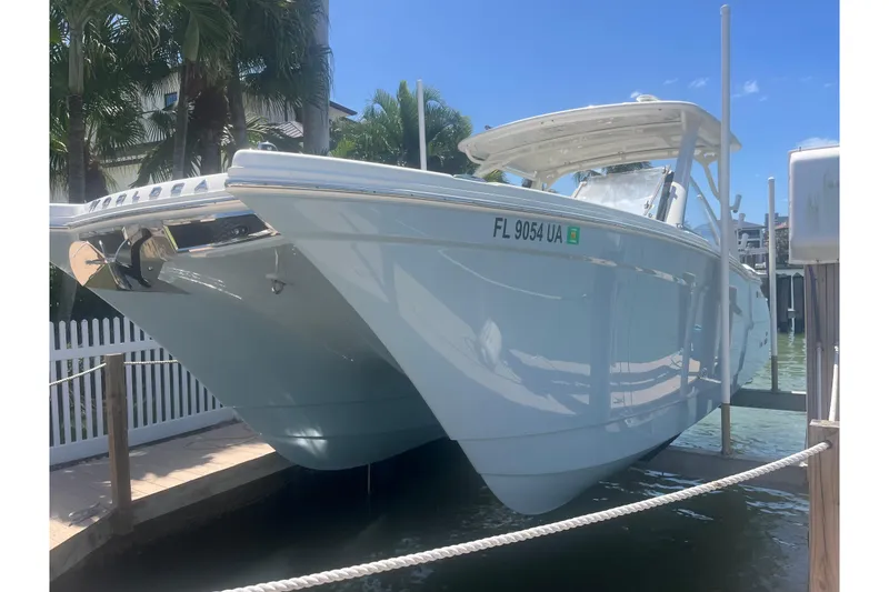 Slide: The Image of 2025 World Cat 280 DC-X boat docked in sunny marina setting. - 0