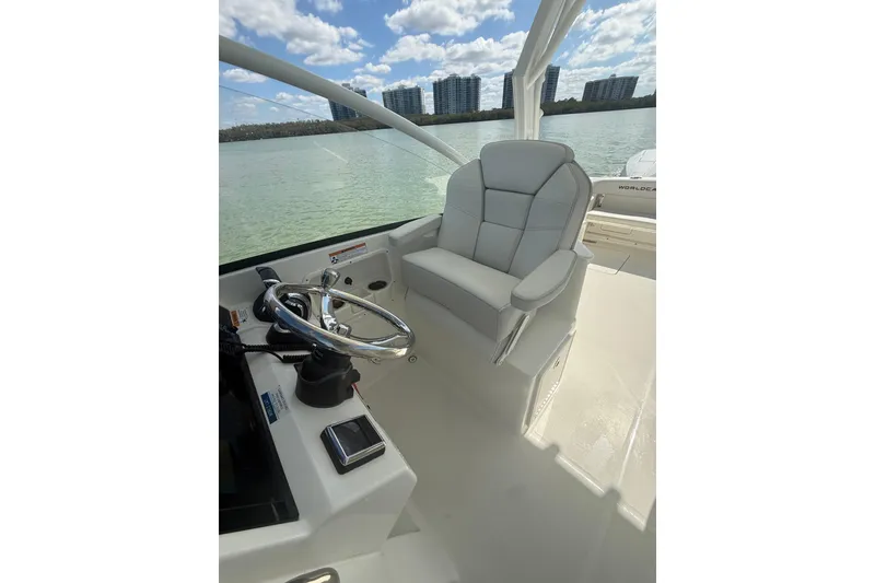 Slide: The Image of Helm of 2025 World Cat 280 DC-X boat with plush seating and steering wheel. - 10