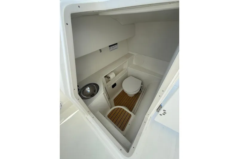 Slide: The Image of 2025 World Cat 280 DC-X boat interior with compact bathroom and sink. - 15