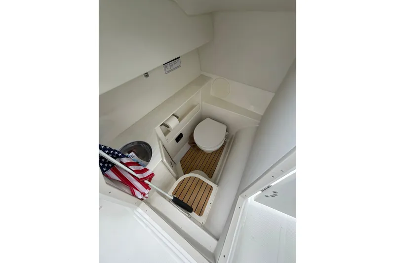 Slide: The Image of Interior of 2025 World Cat 280 DC-X boat featuring a compact marine toilet. - 19
