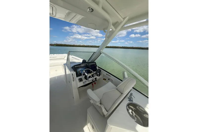 Slide: The Image of 2025 World Cat 280 DC-X helm with dual screens, steering wheel, and comfortable seating. - 4