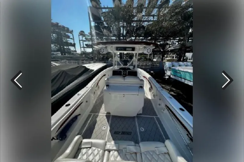 Slide: The Image of 2015 Deep Impact 33 boat interior with seating and helm, docked outdoors. - 10