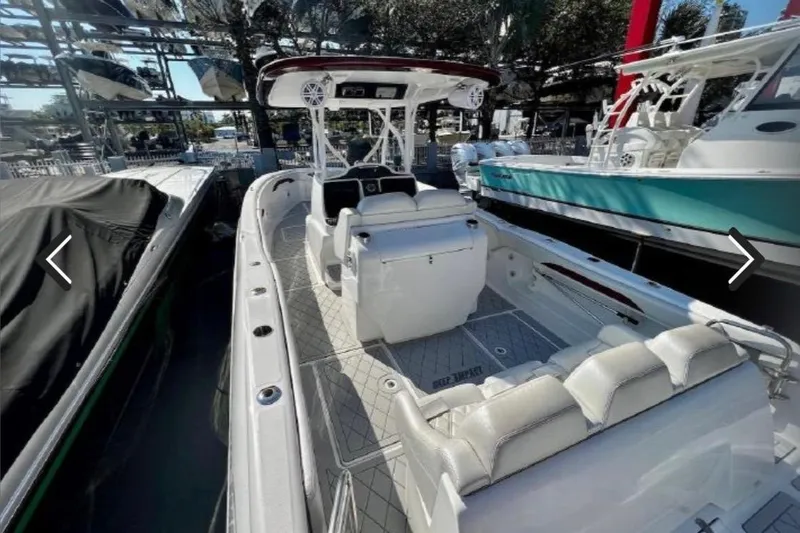 Slide: The Image of 2015 Deep Impact 33 boat with white seating, docked among other boats. - 11