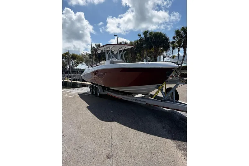 Slide: The Image of 2015 Deep Impact 33 boat on trailer under a partly cloudy sky. - 3