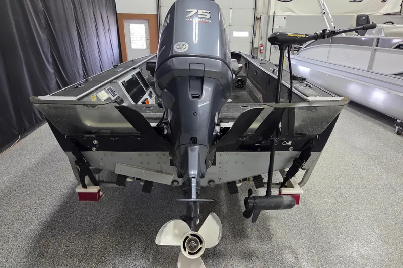 Slide: The Image of 1995 Lund 1775 Pro-V SE boat with 75 horsepower outboard motor in a garage. - 5