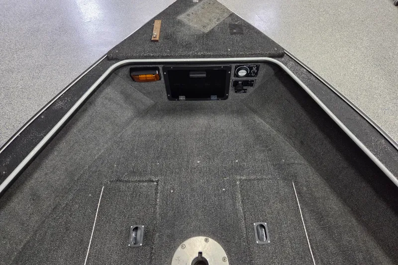 Slide: The Image of Interior of a 1995 Lund 1775 Pro-V SE boat, featuring carpeted flooring and control panel. - 7