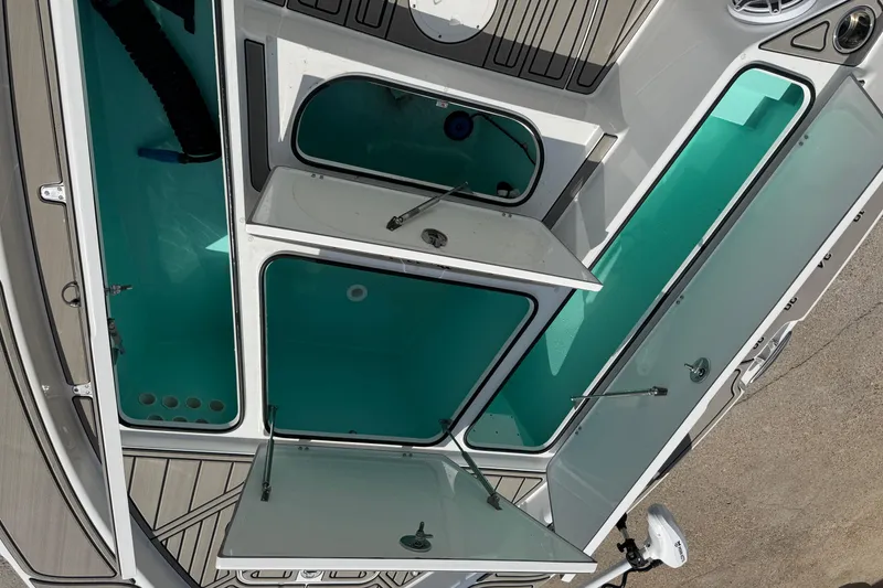 Slide: The Image of 2024 BlackJack 256 Bay boat compartments with open hatches, showcasing storage space. - 13