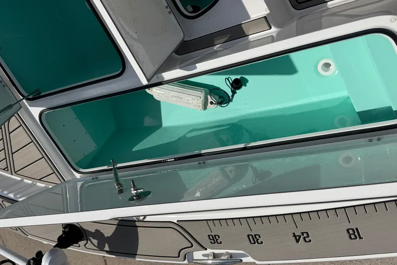 Slide: The Image of Open storage compartment on a 2024 BlackJack 256 Bay boat, featuring a measuring ruler. - 14