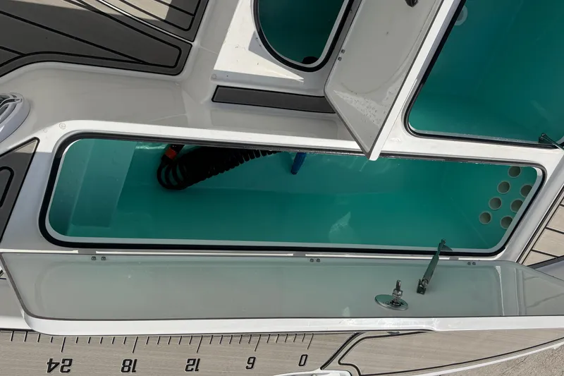 Slide: The Image of Open storage compartments on a 2024 BlackJack 256 Bay boat, showcasing interior design. - 16