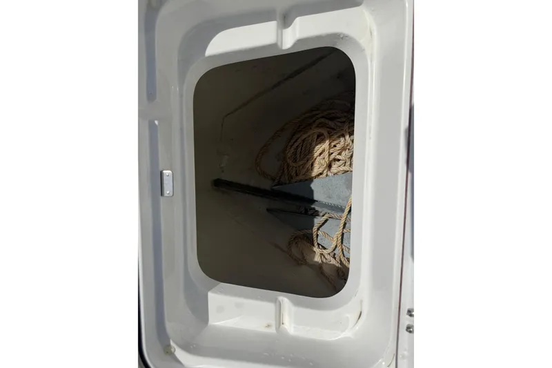Slide: The Image of Anchor storage compartment on 2024 BlackJack 256 Bay boat, featuring rope and anchor. - 18