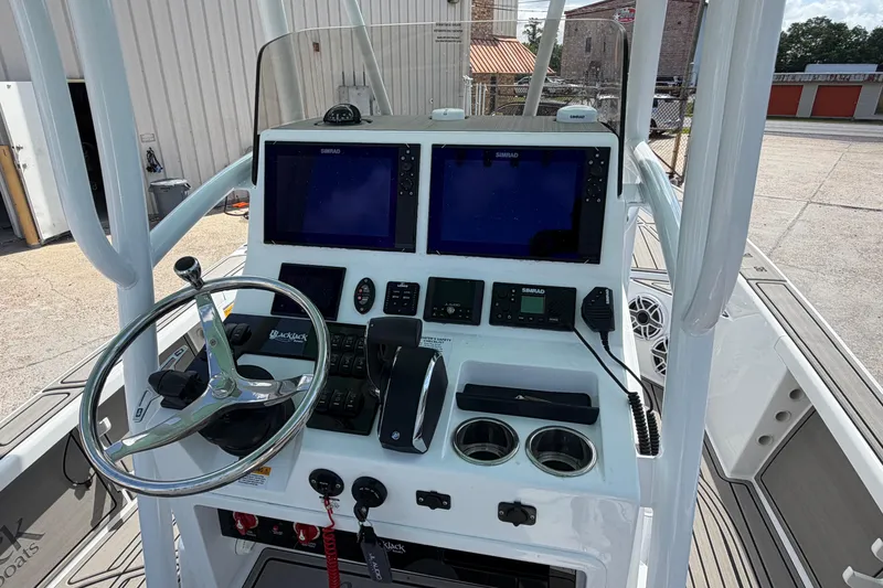 Slide: The Image of 2024 BlackJack 256 Bay boat dashboard with steering wheel and navigation screens. - 21