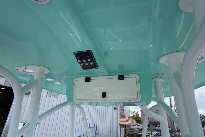 Slide: The Image of 2024 BlackJack 256 Bay boat interior, featuring teal ceiling, control panel, and storage compartment. - 22