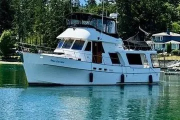 The Image of 1982 C @ L Sea Ranger yacht on tranquil water with lush forest backdrop. - 0