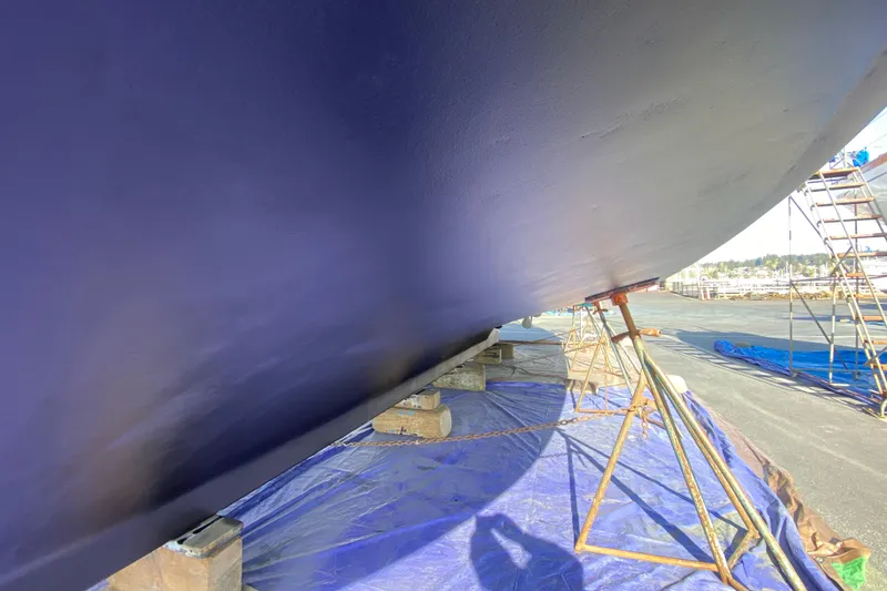 Slide: The Image of Underneath view of a 1982 C & L Sea Ranger boat on stands, with blue tarp and scaffolding. - 12