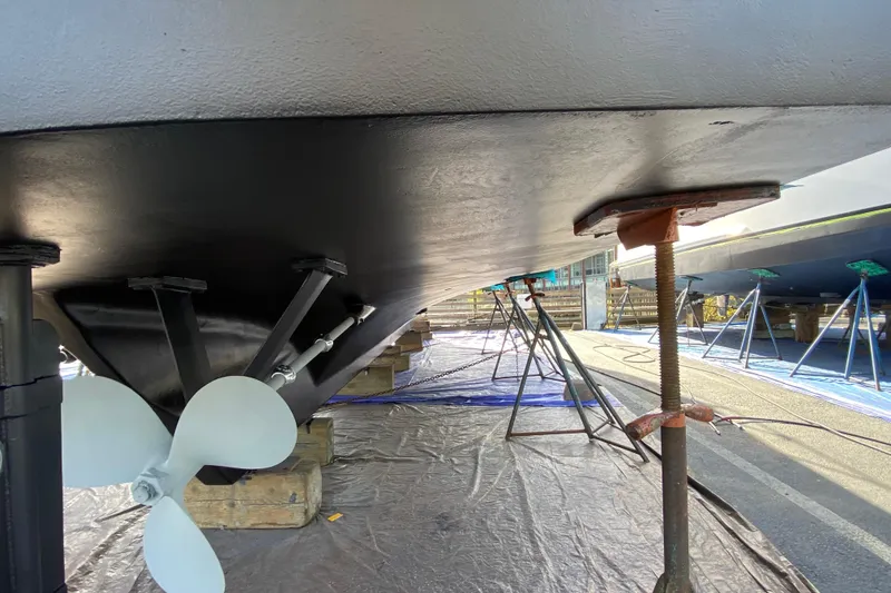 Slide: The Image of Underneath view of a 1982 C & L Sea Ranger boat on dry dock, showing propeller and supports. - 16