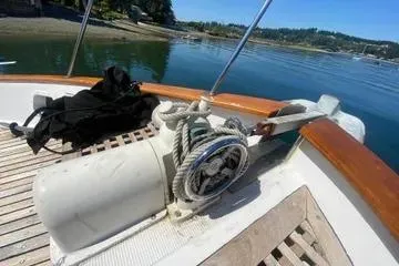 Slide: The Image of 1982 C @ L Sea Ranger boat deck with winch and rope, overlooking calm waters. - 18