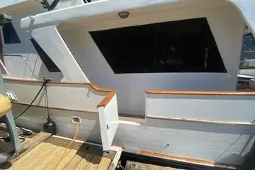 Slide: The Image of 1982 C @ L Sea Ranger boat docked, featuring white exterior and wooden trim. - 24