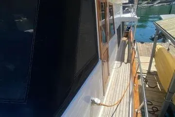 Slide: The Image of 1982 C @ L Sea Ranger yacht docked, showcasing wooden deck and cabin details. - 27