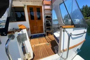 Slide: The Image of 1982 C @ L Sea Ranger boat with wooden deck and glass doors, docked by water. - 29
