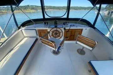 Slide: The Image of 1982 C @ L Sea Ranger boat interior with steering wheel and seating, overlooking calm waters. - 40