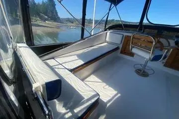Slide: The Image of 1982 C @ L Sea Ranger boat interior with seating and helm, docked by a scenic shoreline. - 42