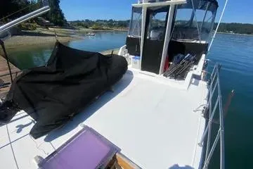 Slide: The Image of 1982 C @ L Sea Ranger boat on calm water, featuring spacious deck and covered cockpit. - 45