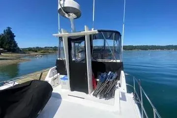 Slide: The Image of 1982 C @ L Sea Ranger boat on calm water, clear sky, and scenic shoreline. - 47